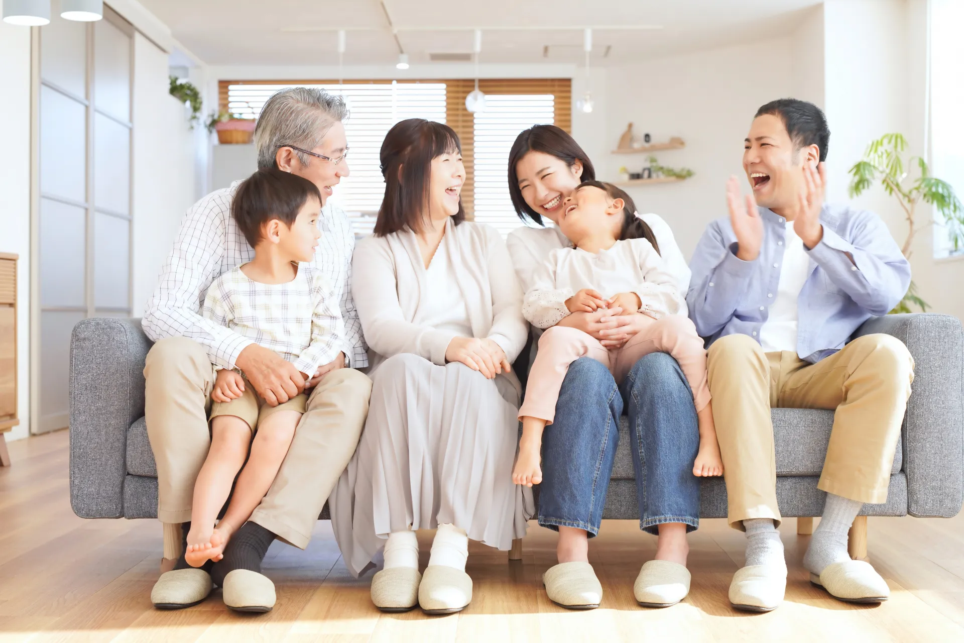 笑顔でリビングでくつろいでいる家族の様子